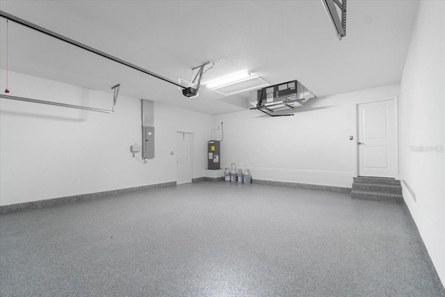10061 Gulfstream Blvd, Englewood, FL 34224 - garage featuring water heater, electric panel, a garage door opener, and baseboards