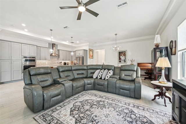 living room with ornamental molding, ceiling fan with notable chandelier, and light hardwood / wood-style floors