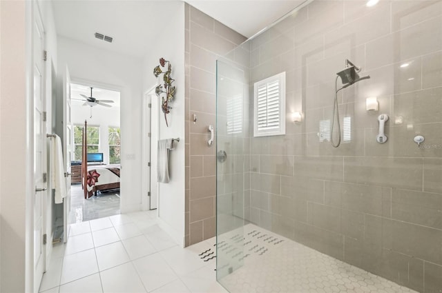 bathroom with ceiling fan, tile patterned flooring, and tiled shower