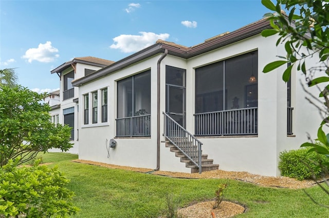 view of side of property with a yard and a sunroom