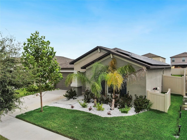 view of side of property featuring solar panels, a yard, an attached garage, fence, and stucco siding