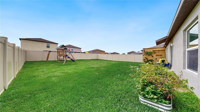 view of yard with a fenced backyard and a playground