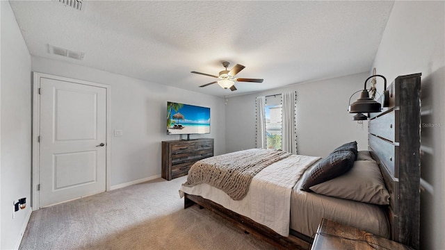 bedroom featuring visible vents, baseboards, carpet, and a textured ceiling