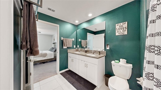 bathroom with toilet, vanity, and tile patterned floors