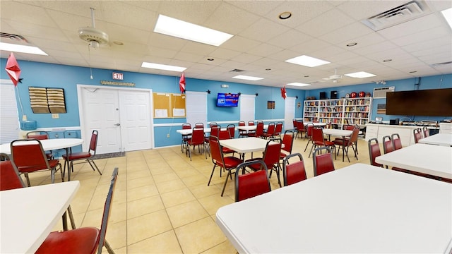 tiled dining area with a paneled ceiling