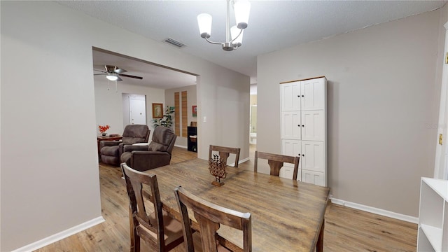 dining room featuring a textured ceiling, ceiling fan with notable chandelier, and light hardwood / wood-style floors