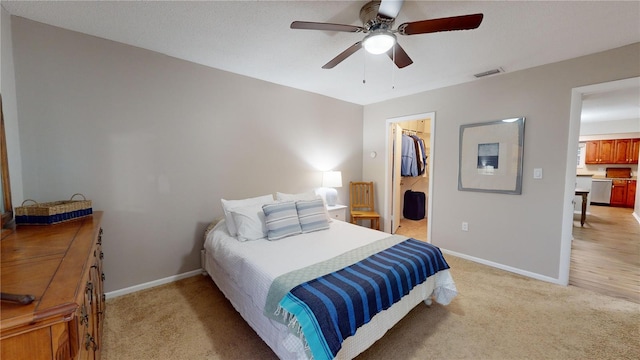 carpeted bedroom featuring a spacious closet, a closet, and ceiling fan