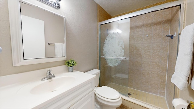 bathroom featuring a textured ceiling, vanity, toilet, and an enclosed shower