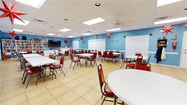 dining space with a drop ceiling and light tile patterned floors