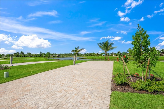 view of home's community with a lawn and a water view