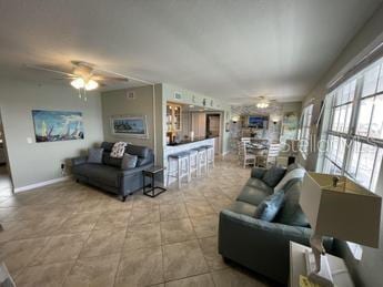 living room featuring ceiling fan and light tile patterned flooring