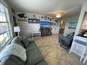 tiled living room with ceiling fan and plenty of natural light