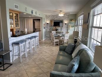 tiled living room featuring ceiling fan