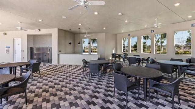 carpeted dining area featuring ceiling fan and a wealth of natural light