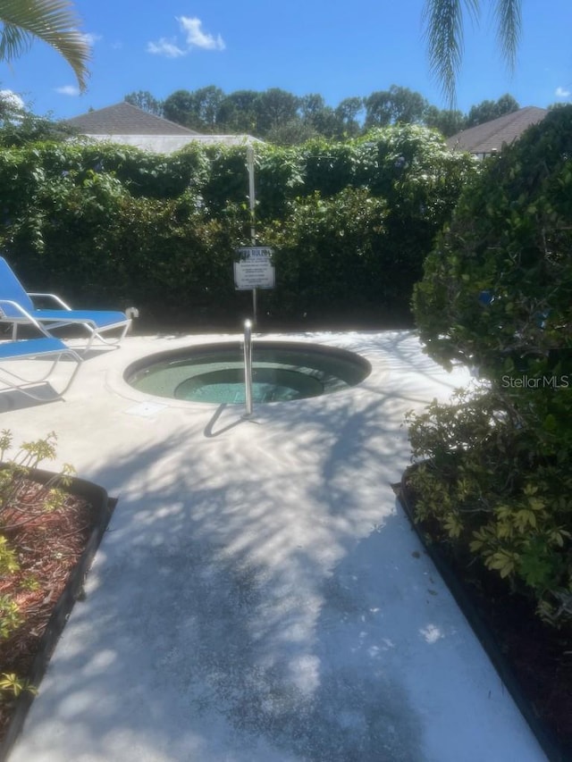 view of pool featuring a community hot tub and a patio area