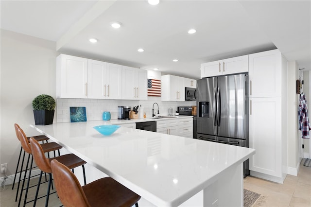 kitchen featuring a breakfast bar, sink, decorative backsplash, kitchen peninsula, and white cabinetry