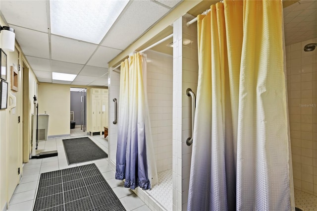 bathroom with walk in shower, a drop ceiling, and tile patterned floors