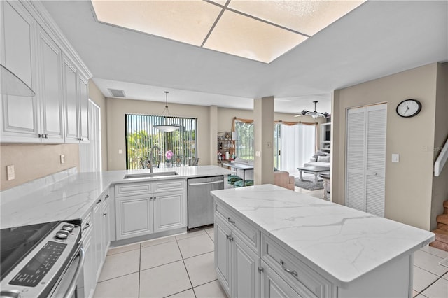 kitchen featuring a center island, sink, white cabinets, kitchen peninsula, and stainless steel appliances