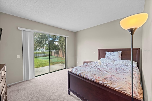 carpeted bedroom with a textured ceiling and access to outside