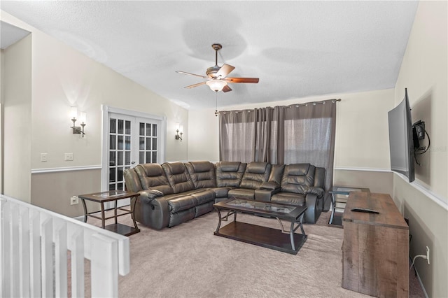 carpeted living room with lofted ceiling, ceiling fan, and a textured ceiling