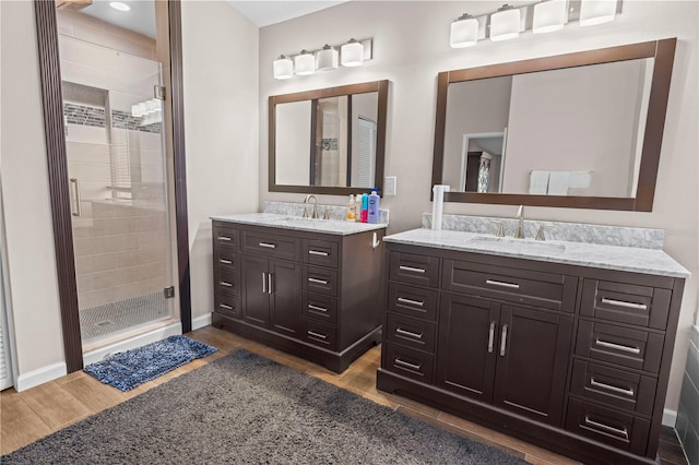 bathroom featuring wood-type flooring, vanity, and a shower with shower door