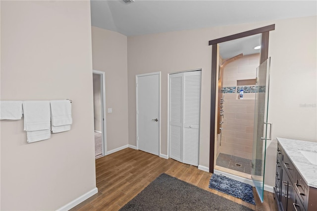 bathroom featuring a shower with door, hardwood / wood-style flooring, and vanity