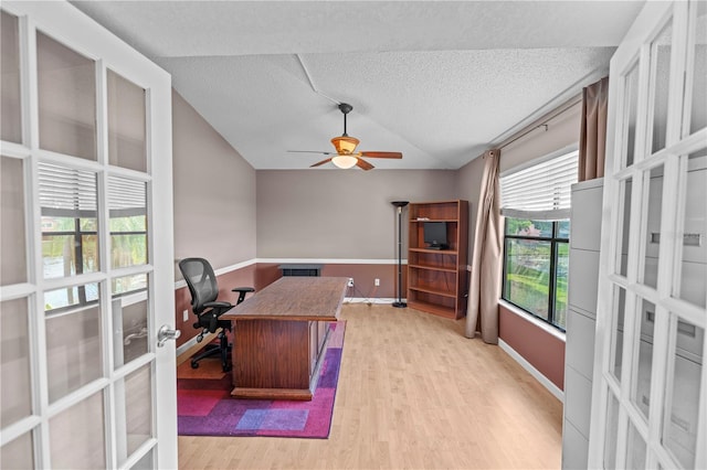 office featuring ceiling fan, a textured ceiling, light wood-type flooring, and lofted ceiling