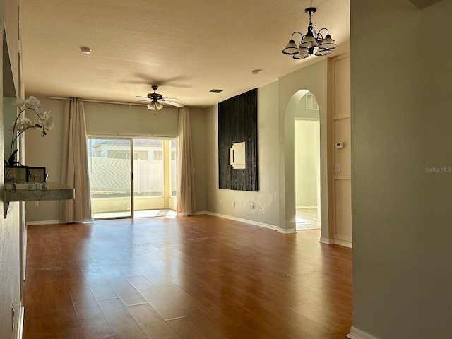 spare room featuring a textured ceiling, ceiling fan with notable chandelier, and hardwood / wood-style flooring