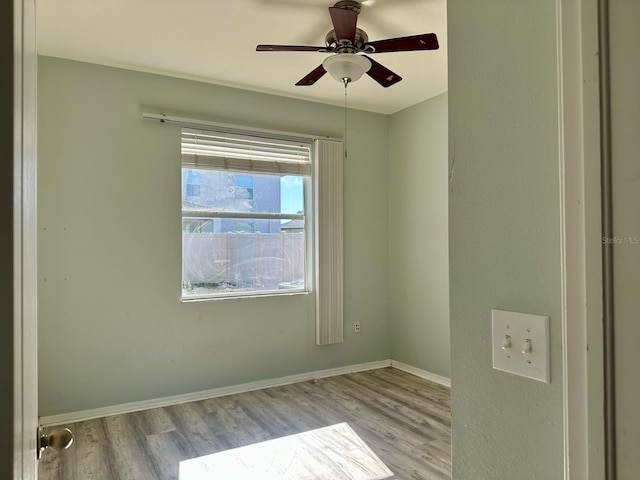 spare room with ceiling fan and light wood-type flooring