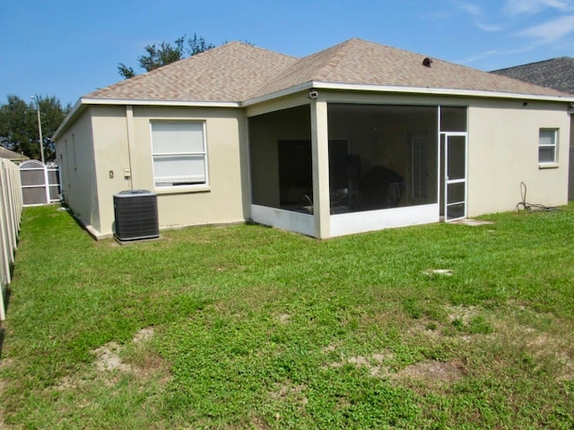 back of house featuring a yard, a sunroom, and central air condition unit