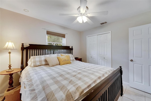 tiled bedroom with ceiling fan and a closet