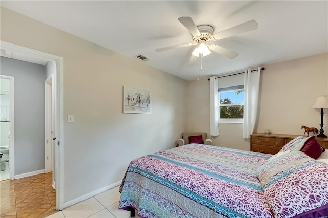 tiled bedroom featuring connected bathroom and ceiling fan