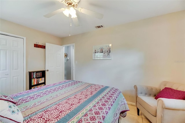 tiled bedroom with ceiling fan and a closet