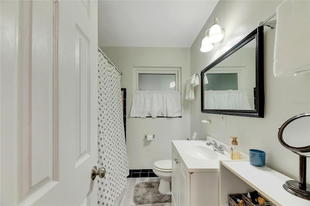 bathroom with walk in shower, vanity, and toilet