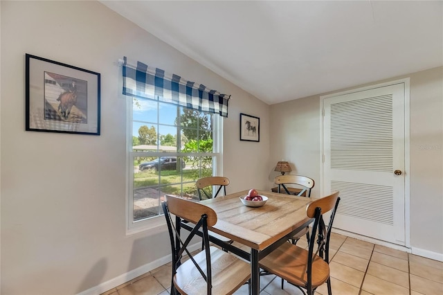 dining room featuring light tile patterned flooring and lofted ceiling