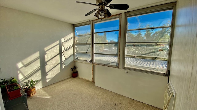 unfurnished sunroom featuring ceiling fan