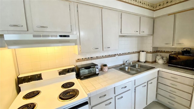 kitchen featuring sink, white cabinets, backsplash, tile countertops, and white range with electric cooktop