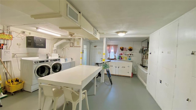 kitchen featuring white cabinets, electric panel, and washing machine and dryer