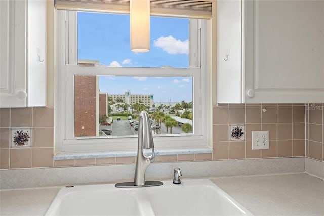 details with white cabinets, backsplash, and sink