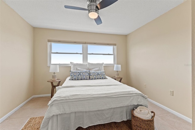 carpeted bedroom with multiple windows, ceiling fan, and a textured ceiling