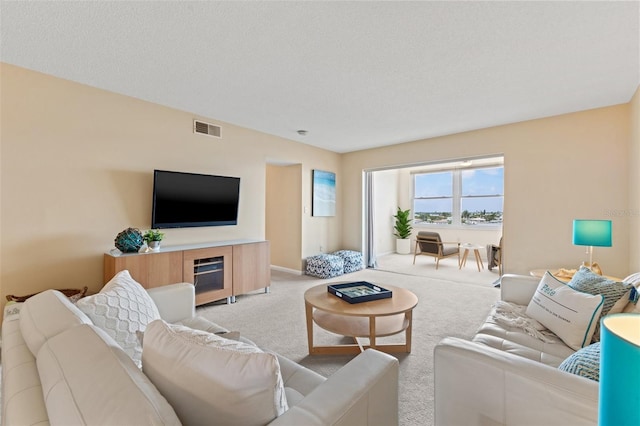 carpeted living room featuring a textured ceiling