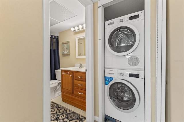 washroom with tile patterned floors, stacked washer / dryer, and sink