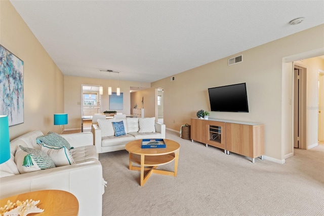carpeted living area featuring visible vents and baseboards