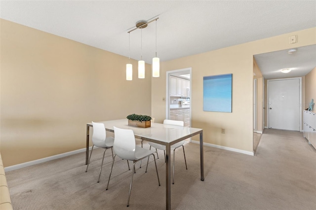 dining room featuring baseboards and light carpet