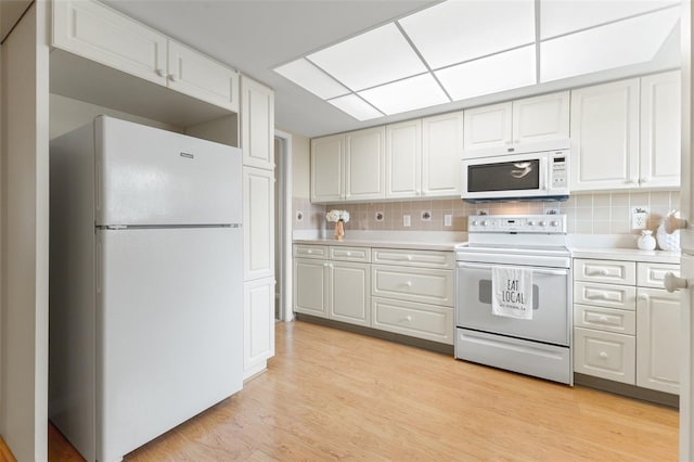 kitchen featuring light countertops, white cabinets, and white appliances