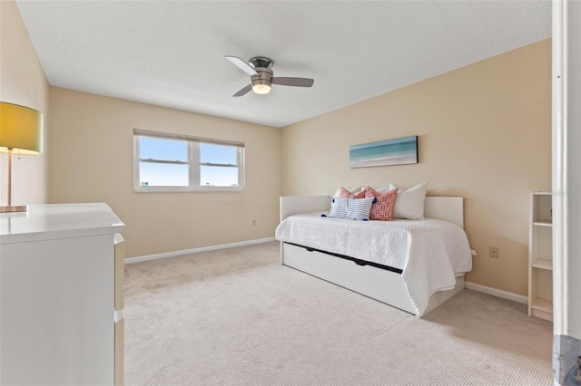 bedroom with light colored carpet, a ceiling fan, and baseboards