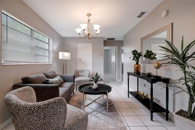 living room with a chandelier, a textured ceiling, and light tile patterned floors