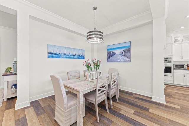 dining room featuring wood-type flooring, ornamental molding, and a chandelier