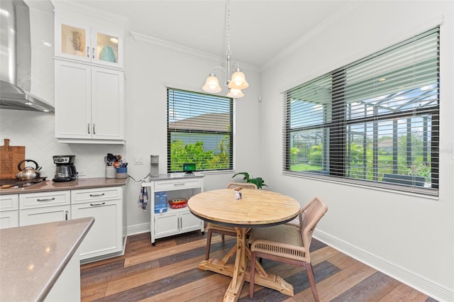 interior space with a notable chandelier, crown molding, dark wood-type flooring, and a wealth of natural light