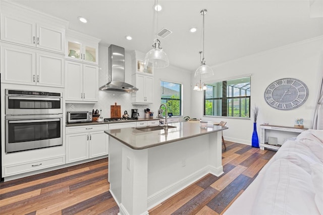 kitchen featuring wall chimney exhaust hood, white cabinetry, sink, and dark hardwood / wood-style flooring